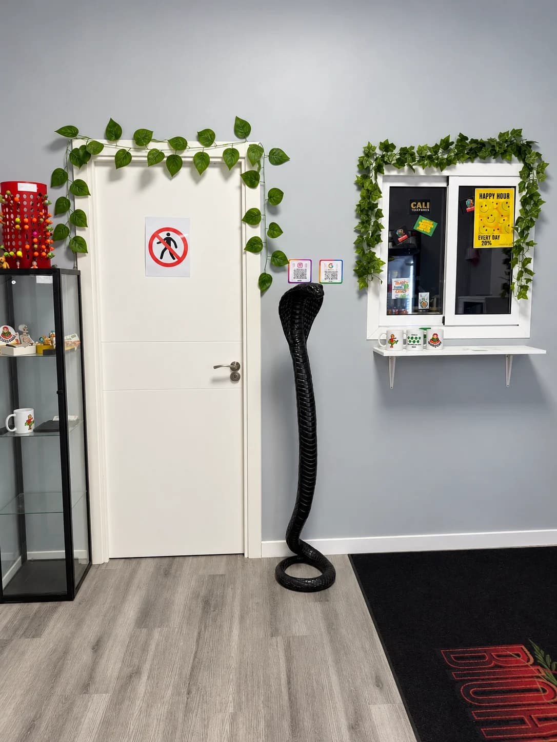 Weed Club Malasaña interior with a display cabinet, decorative plants and a cobra figure